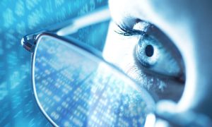 Woman with computer screen reflecting in glasses