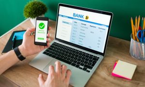 wire-transfer-young-man-using-his-smartphone-laptop-banking-transaction-some-payments-1000x600-2